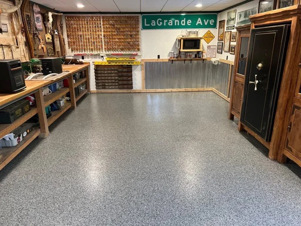 A finished basement workspace with gray, white, and black flecked concrete flooring.