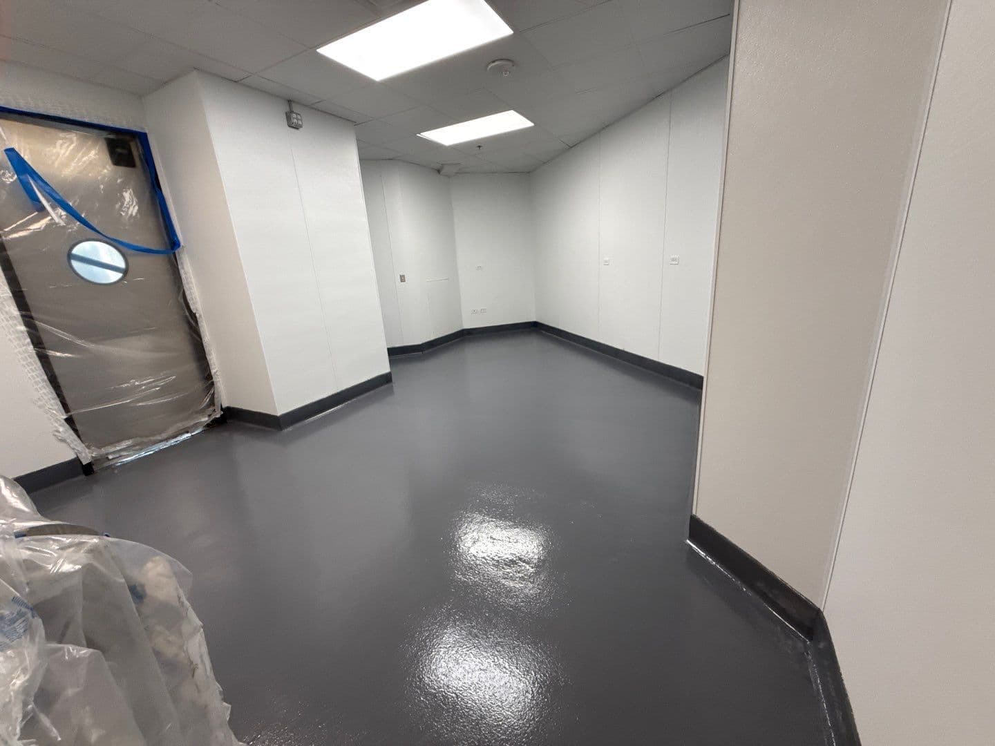 A commercial restaurant kitchen space with newly-coated solid gray concrete flooring.