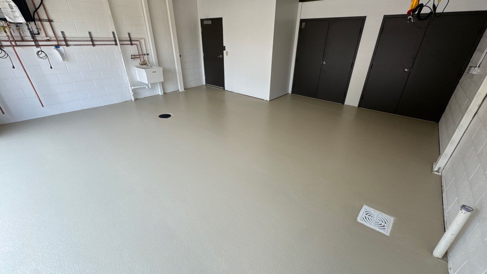 A commercial warehouse space with solid beige-colored quartz flooring.