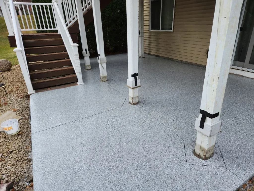 An outdoor patio with new light gray flecked concrete coated flooring.