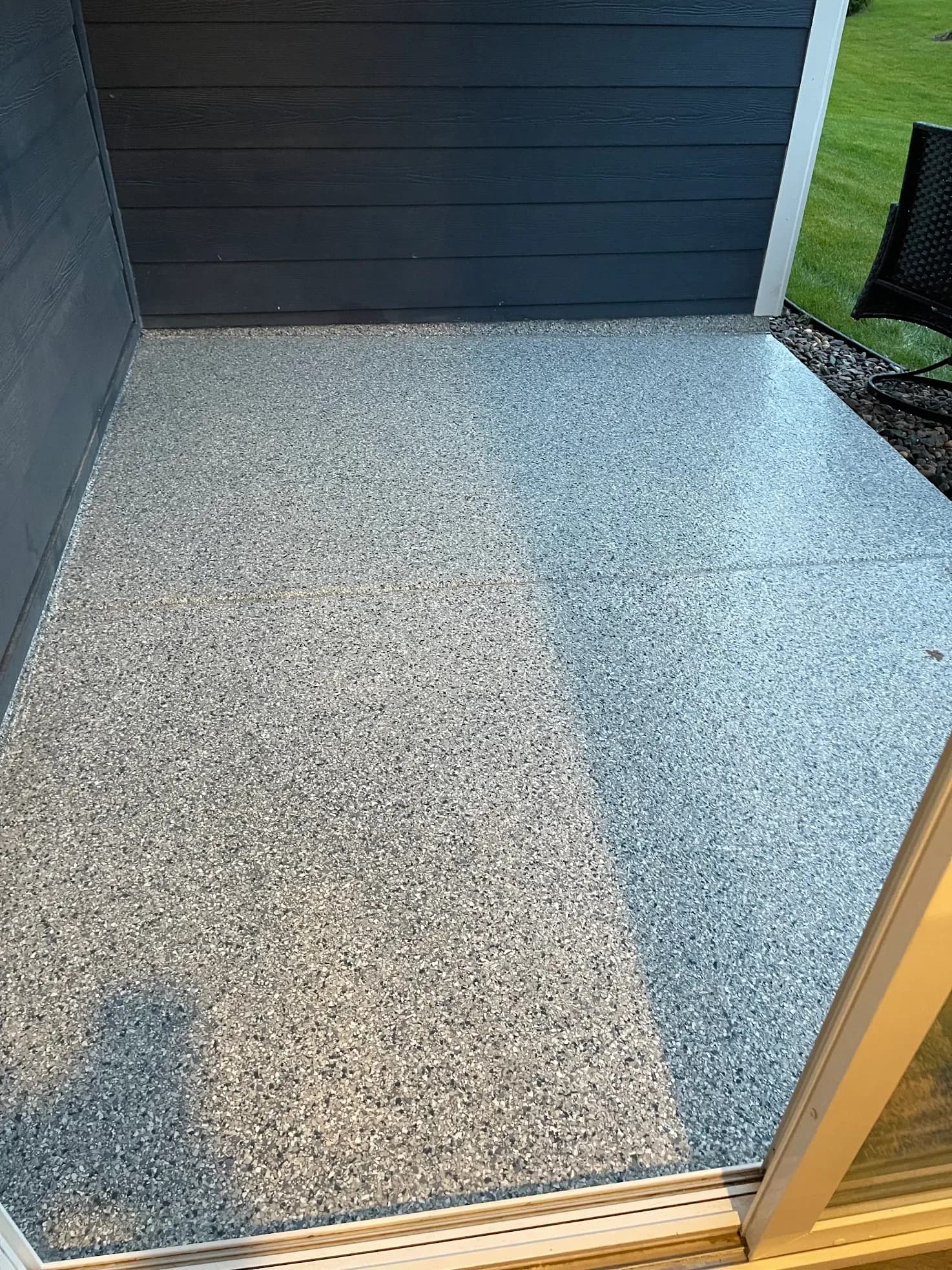 A patio with black, white, and gray flecked concrete coating flooring.