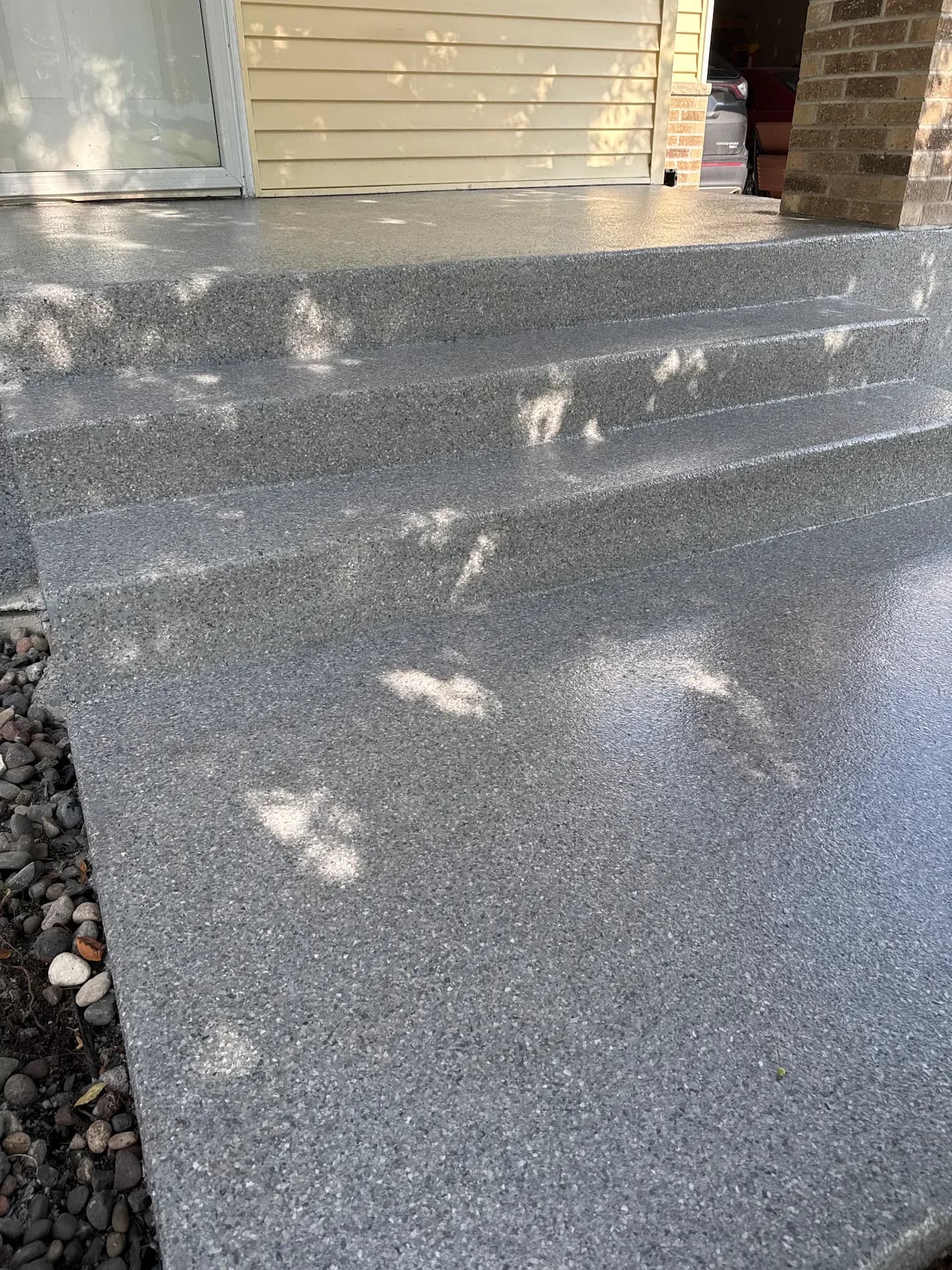 Medium gray flecked concrete coated patio steps.