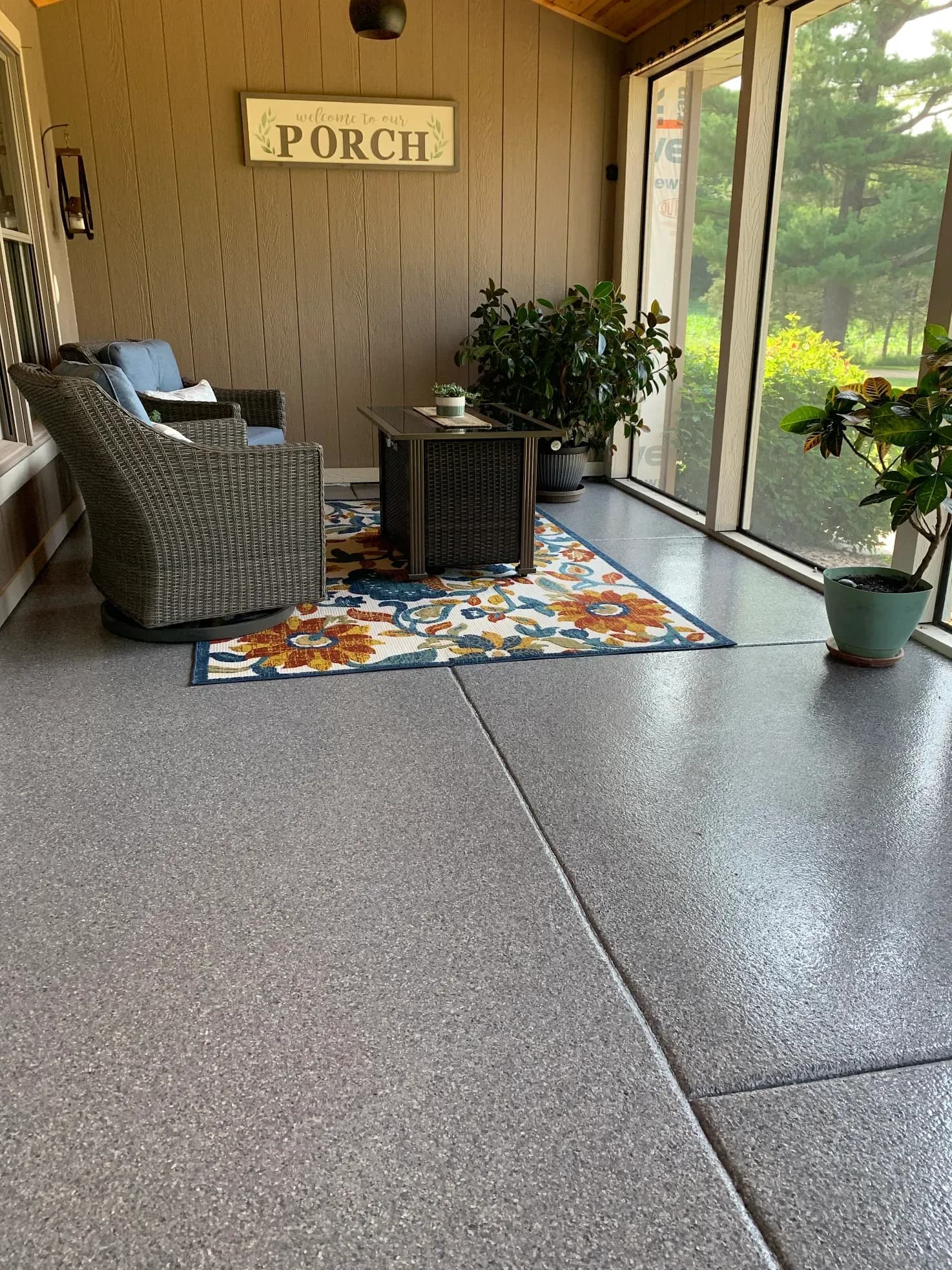 A screened patio sunroom with newly-coated gray flecked concrete flooring.