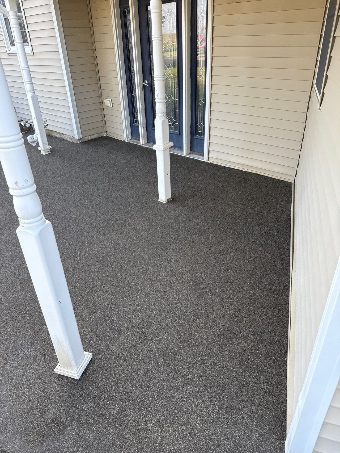 A newly-coated dark-colored Resist front patio.