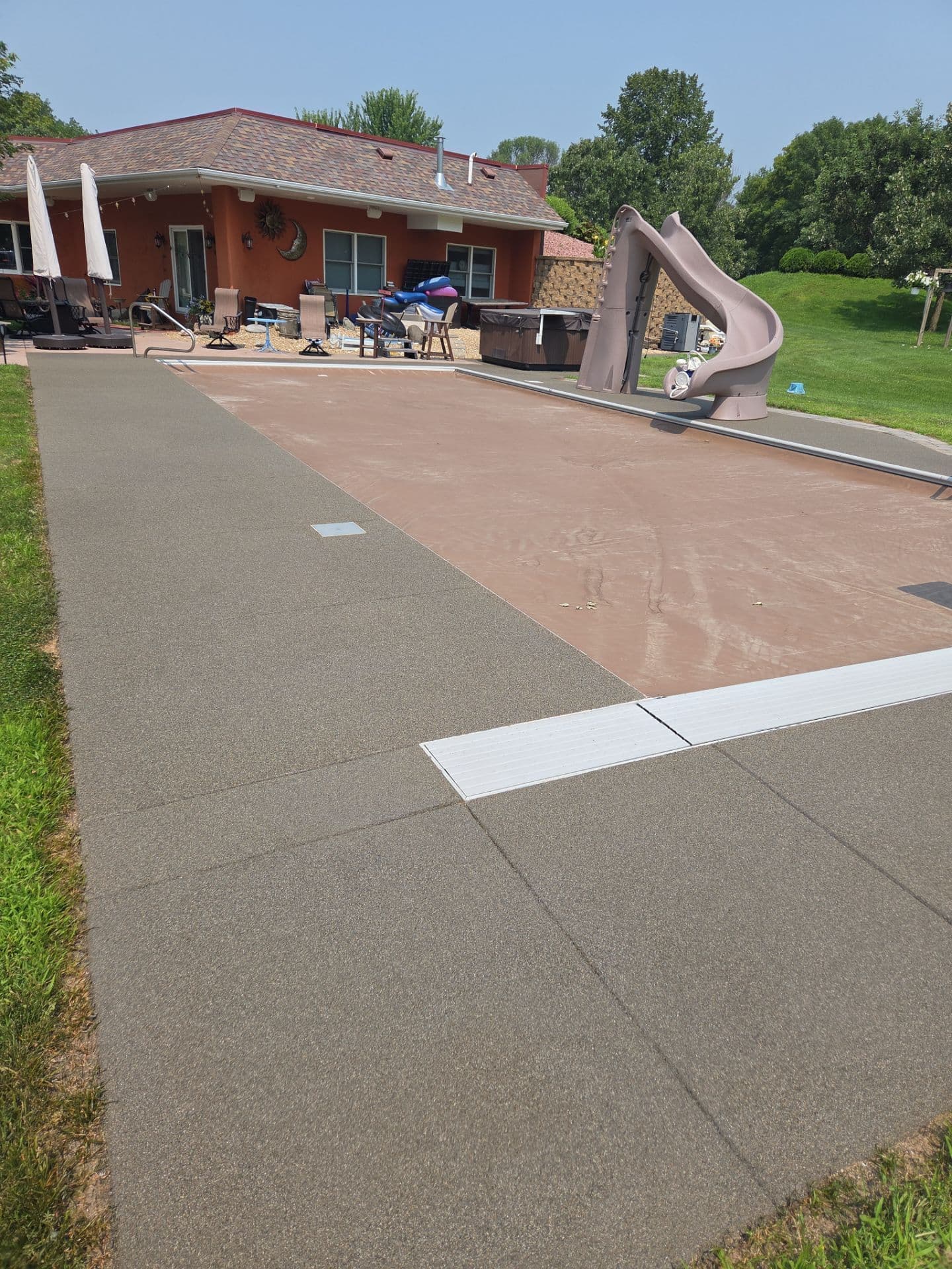 A newly-coated brown Resist pool deck.